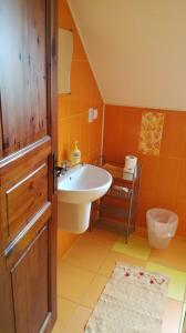 uma casa de banho com um lavatório, um WC e uma porta em Penzión Ranč Šenkvice em Veľké Čaníkovce