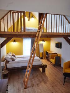 Zimmer mit 2 Etagenbetten und einer Leiter in der Unterkunft La Forge in Ringendorf