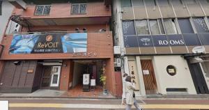 a person crossing a street in front of a building at Nishi Nakasu apartment 301 in Fukuoka