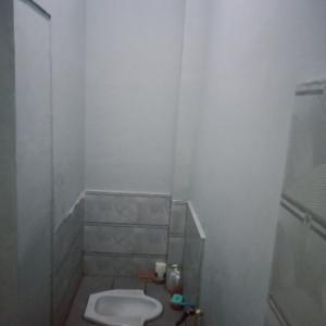 a white bathroom with a toilet and a shower at SPOT ON 2831 Pondok Orange Family in Makassar