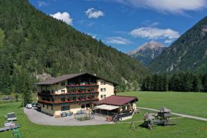 un gran edificio en un campo con montañas en el fondo en Schönauer Hof, en Bach