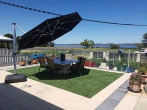 a patio with a table and chairs under an umbrella at The DOLPHIN PLACE in Australind