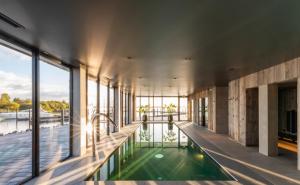 an indoor pool in a building with a view of the water at Waterrijk Oesterdam Hotel in Tholen