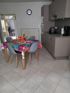 a kitchen with a table with chairs and a table cloth at Le Mas du Paulou in Vallon-Pont-dʼArc