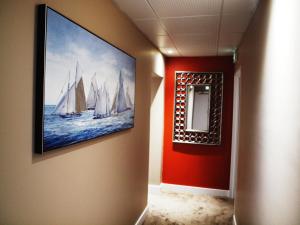 a hallway with a painting of boats on the wall at Hôtel Baptistin in Le Lavandou