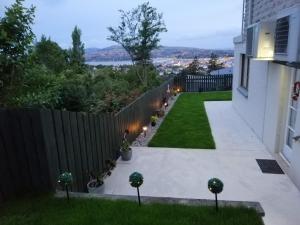einen Hinterhof mit einem Zaun und einem Garten in der Unterkunft Beautiful Panoramic views in Dunedin