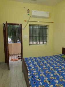 een slaapkamer met een bed en een raam bij Raghavi Tourist Home in Kanyakumari