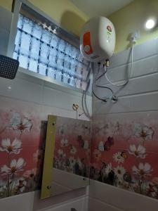 a camera on the wall of a bathroom with flowers at Raghavi Tourist Home in Kanyakumari