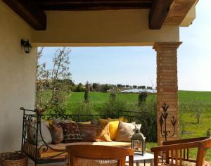 porche con sofá y vistas al campo en Villa Belvedere, en Marsiliana