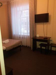 a room with a bed and a desk and a window at Гостиница "SEMEY-CITY" in Semey