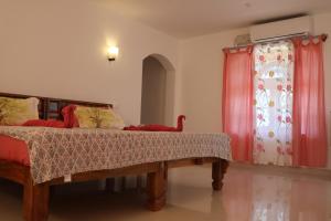 A bed or beds in a room at Magnolia Guesthouse Varkala