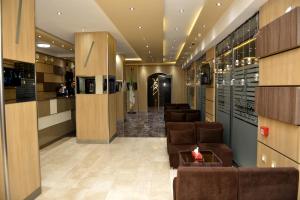 een lobby met een rij stoelen en wijnflessen bij HOTEL AMSTERDAM in Rouiba