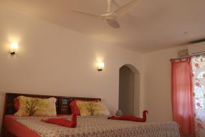 a bedroom with two red animal pillows on a bed at Magnolia Guesthouse Varkala in Varkala