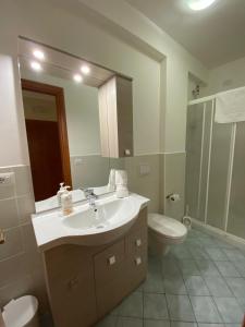 a bathroom with a sink and a toilet and a mirror at Nick & Santo's Holiday Homes B&B in Giardini Naxos