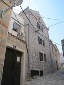 an old stone building with a gate and a garage at Apartments Voltera parking space near the house in Betina