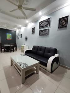 uma sala de estar com um sofá e uma mesa em DF ZaheenulFitri Homestay (Muslim Homestay) em Seremban