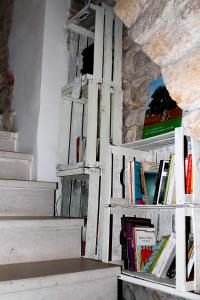 een boekenplank met boeken erop naast een trap bij Il Mulino di Amleto - Bed and Breakfast letterario in Molfetta