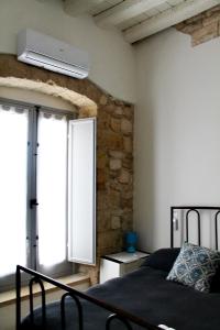 a bedroom with a bed and a window with a air conditioner at Il Mulino di Amleto - Bed and Breakfast letterario in Molfetta