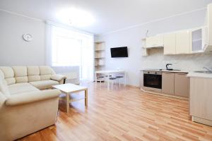a living room filled with furniture and a kitchen at Apartments "Rooms" in Yekaterinburg