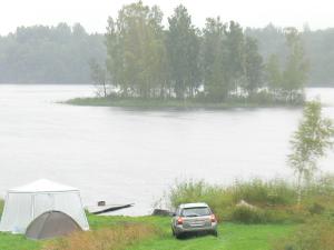 un coche estacionado junto a una tienda y un lago en International Camp club Bereg Best Beach Stylish Coastline Ukleyno Lake National Park Valdai, en Maloye Ukleyno