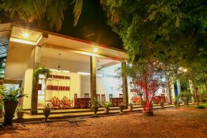 un edificio con un porche con sillas y árboles en Dearly Holiday Home And Safari, en Tissamaharama