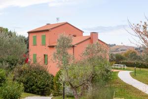 una casa arancione con finestre verdi e un sentiero di A3Passi ad Ancona