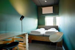 a bedroom with a bed with a desk and a chair at Urban Camper Hostel & Bar in Copenhagen