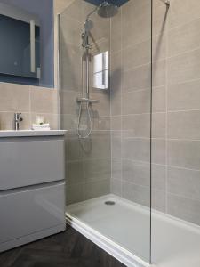 a bathroom with a shower with a tub and a sink at Harmony Bed and Breakfast in Torquay