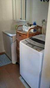 a kitchen with a refrigerator and a washing machine at 町中ステイ 宗ハウス in Nachikatsuura