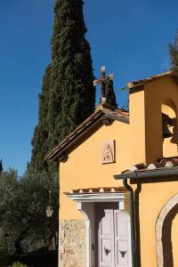 Una iglesia con una cruz encima. en Tenuta La Bandita en Sassetta