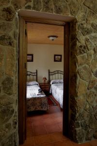 Habitación con 2 camas y pared de piedra. en casa rio alberche y el cortijo de gredos, en Navaluenga 38 fotos más