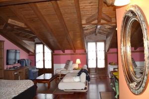 a person sitting on a couch in a room with a mirror at Apartamentos La Buhardilla in Ezcaray