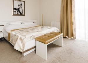 a bedroom with a white bed with a stool at Hotel Court Wellness&Spa in Kędzierzyn-Koźle