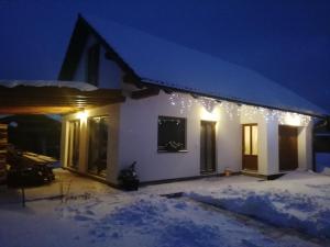 ツベレツにあるDomček Michaelaの雪中のクリスマス灯付きの家