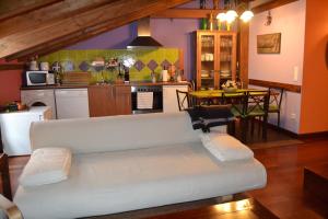 a living room with a couch and a kitchen at Apartamentos La Buhardilla in Ezcaray
