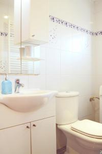 a white bathroom with a sink and a toilet at Apartment Incognito in Sarajevo