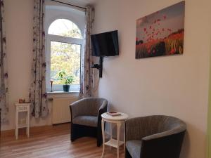 a living room with two chairs and a table and a window at Fewo "Mohnblume" am Stadtpark in Lutherstadt Wittenberg