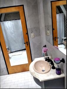 y baño con lavabo y espejo. en Trastienda Guest House en El Calafate