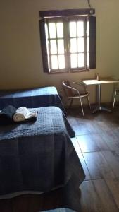a bedroom with two beds and a table and a window at Finca Las Pircas Casa de Adobe in Famatina