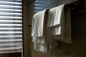łazienka z białymi ręcznikami wiszącymi na wieszaku na ręczniki w obiekcie Albergo Mirella w mieście Belluno