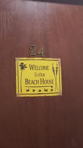 un panneau sur une porte avec un message de bienvenue dans notre maison de plage dans l'établissement APTO UBATUBA Maranduba 80 mt praia, à Ubatuba