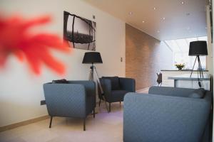 sala de estar con sofás y TV en la pared en Maison Romeo, en Brujas