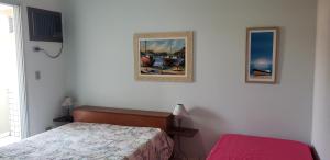 une chambre avec un lit et un tableau au mur dans l'établissement APTO UBATUBA Maranduba 80 mt praia, à Ubatuba