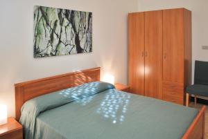 - une chambre avec un lit, une armoire et une chaise dans l'établissement Al Villino Sunrise appartamento in villa con piscina, à SantʼAlfio 31 autres photos