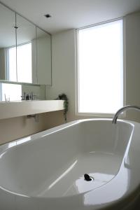 a white bath tub in a bathroom with a window at Docklands Luxury Penthouse Right Above The District Docklands in Melbourne +76 photos