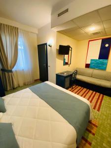 a hotel room with a large bed and a couch at Hotel Della Baia in Portovenere