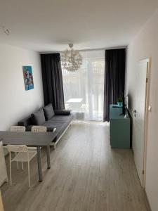 sala de estar con sofá y mesa en Apartamenty Bursztynowe w Kołobrzegu Sun&Relax, en Kołobrzeg