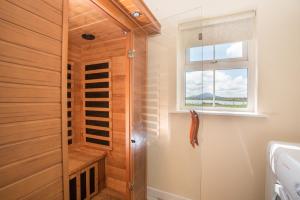 a bathroom with a walk in shower next to a window at Doherty Farm Holiday Homes in Downings +23 photos