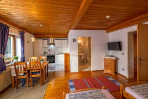 a kitchen and living room with a table and chairs at Ferienwohnungen Am Sonnenhang in Theisseil