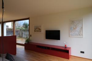 a living room with a flat screen tv on a wall at Ferienhaus S11 Lustenau in Lustenau